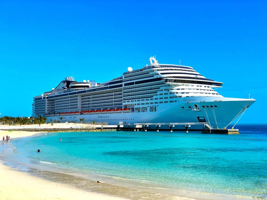 A luxury cruise ship gliding across calm turquoise ocean water